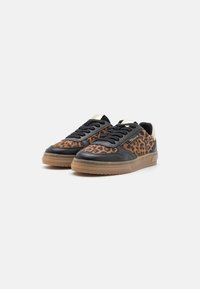 Baskets en cuir à motif léopard noir et beige, avec des lacets noirs et une semelle en caoutchouc. Présentent un logo doré sur le côté.