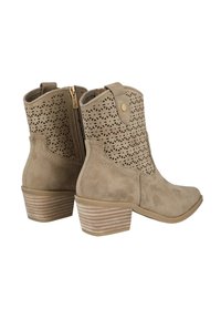 Botines de ante beige con diseño recortado, cremalleras laterales y un tacón apilado a rayas. Textura suave y forma de punta redonda.
