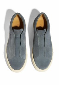 Sive suede cipele bez vezica s okruglim vrhom, s bež gumiranim đonom i minimalističkim detaljima šivanja na gornjem dijelu.