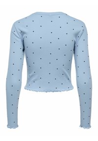 Haut à manches longues bleu clair à pois noirs, avec un ourlet et des poignets effilochés. Confectionné en tissu côtelé pour un aspect texturé.