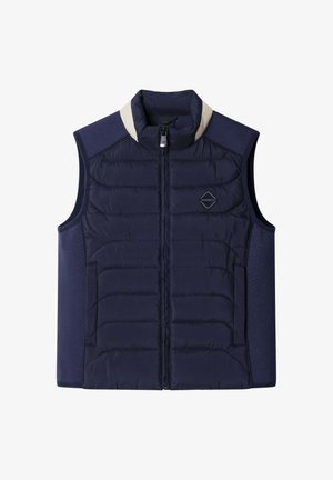 Chaleco acolchado azul marino con cuello alto, cierre frontal con cremallera, textura ligera acolchada y detalles contrastantes en los hombros en beige.