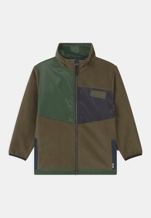 Veste polaire marron avec des blocs de couleur verts et noirs, col montant, fermeture éclair complète à l'avant et poches latérales zippées.