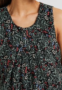 Top in tessuto nero con stampa floreale dai fiori rossi, blu e bianchi. Collo rotondo, senza maniche e con texture plissettata.