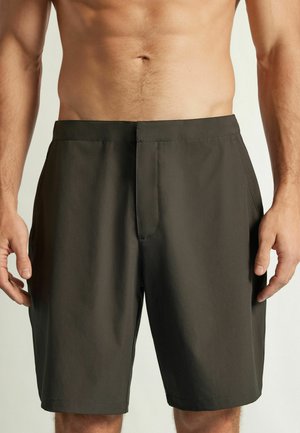 Slim fit donkergrijze herenshorts met een vlakke voorkant en zijzakken, gedragen door een shirtloos mannelijk model tegen een effen achtergrond.
