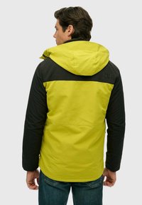 Hættetrøje med en lys limegrøn front og sorte ærmer, med en hel ryg og logodetaljer på skulderen. Glat tekstur.