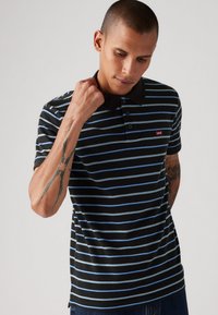 Black and blue striped polo shirt with a black collar and three buttons, featuring a small red Levi's logo on the chest.