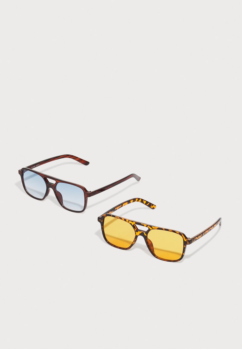 Two pairs of sunglasses: one with a brown tortoiseshell frame and blue lenses, the other with a brown striped frame and yellow lenses.
