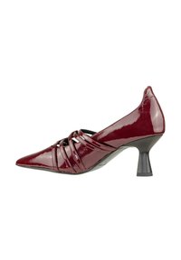 Scarpa con tacco alto in pelle verniciata bordeaux, dalla punta affusolata, con cinturini incrociati sulla parte frontale e un tacco nero di media altezza.