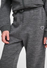 Graue Jogginghosen aus weichem, strukturiertem Stoff, mit einem elastischen Bund und Kordelzug, seitlichen Taschen und einem kleinen gestickten Logo.