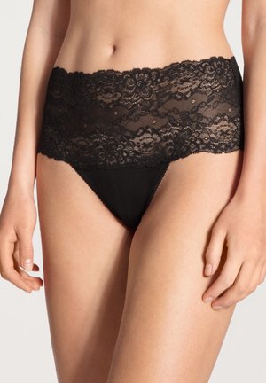 Zwarte kant en nylon damenslip met een brede kanten taille, voorzien van bloempatronen en een gladde, naadloze afwerking.