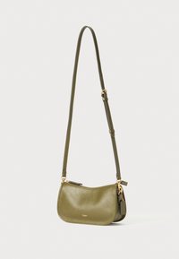 Olive green leather crossbody bag with a curved shape, gold hardware accents, adjustable strap, and a zippered closure.