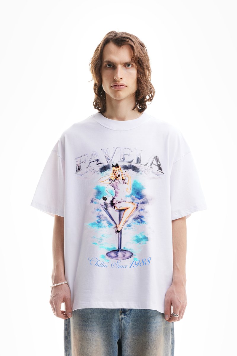 Camiseta blanca de gran tamaño con un gráfico colorido de una mujer en un vaso de cóctel, con el texto "FAVELA" y "Chillin Since 1988."