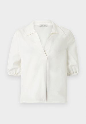Blouse blanche à manches courtes avec un col large et des poignets élastiqués, dotée d'une patte de boutonnage dissimulée sur le devant et d'un ourlet droit.