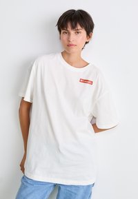 White cotton t-shirt featuring a small red Columbia logo. Classic crew neckline and short sleeves, relaxed fit, smooth texture.