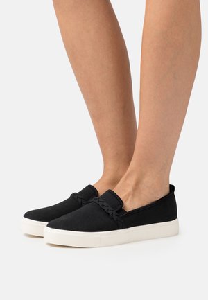 Scarpe slip-on nere in tela con un accento intrecciato testurizzato sul davanti e una suola in gomma bianca, caratterizzate da un design a profilo basso.