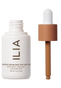 ILIA Super Serum Skin Tint SPF 30 en un frasco blanco, con un tapón cuentagotas marrón. Contiene niacinamida, escualano y ácido hialurónico.