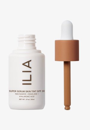 ILIA Super Serum Skin Tint SPF 30 i en vit flaska med ett brunt pipettlock. Innehåller niacinamid, squalan och hyaluronsyra.