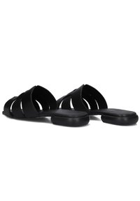 Zwarte slidesandalen van rubber, met een ontwerp van brede banden met uitsparingen, platte zolen en een gladde textuur.