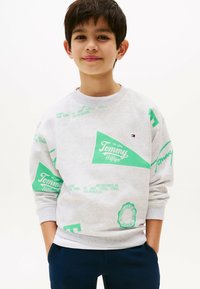 Grijze sweatshirt met groene Tommy Hilfiger-logo's en tekst. Geribbelde manchetten en zoom, ronde halslijn en een zachte textuur. Casual pasvorm.
