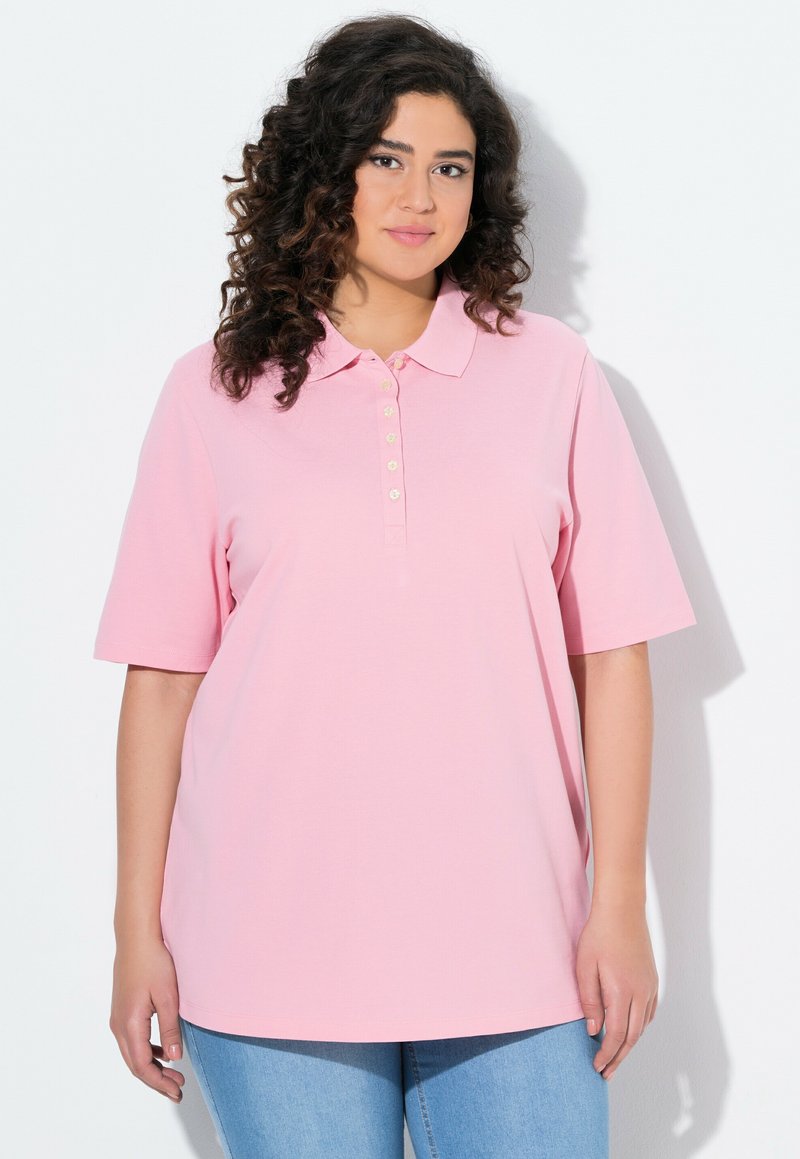 Jasnoróżowa koszulka polo z krótkimi rękawami, klasycznym kołnierzykiem i zapięciem na guziki z przodu. Wykonana z miękkiego, teksturowanego materiału. Luźny krój.