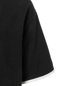 Pull en tricot noir à manches courtes, présentant une surface texturée et des accents côtelés blancs aux bordures des manches.