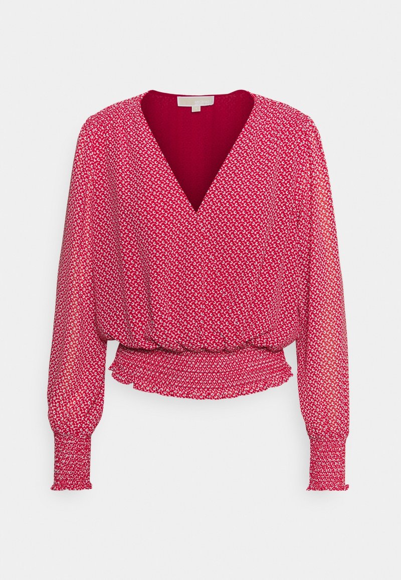 Blouse rouge à manches longues avec petit motif floral blanc, col en V profond, taille froncée et poignets ajustés.