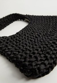 Sac tissé noir en matériau lisse et texturé. Il a un dessus ouvert et une anse robuste, mettant en valeur un design tressé unique.