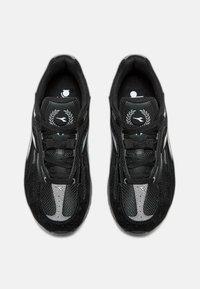 Sneakers atletici neri realizzati in materiali mesh e suede, con accenti argentati a contrasto, forma affusolata e lacci piatti.