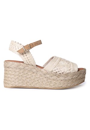 Sandalia de cuña con plataforma de yute natural trenzado, tiras de tela color crema con diseño floral y una correa ajustable al tobillo con hebilla.