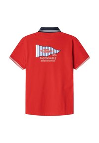 Camiseta polo roja con cuello marino, diseño de bandera a rayas y texto "FAÇONNABLE 1950 SEASIDE EDITION" en la parte posterior. Mangas cortas.