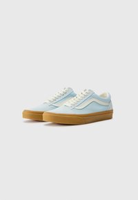 Sneakers din pânză de culoare albastră deschisă cu accente crem, vârf rotunjit și talpă din cauciuc texturat. Au șireturi plate și detaliu cu dungi pe lateral.