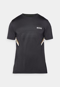 T-shirt noir à manches courtes avec un design texturé, présentant un panneau de petits points, un logo "BOSS" blanc, et des accents dorés et blancs sur les côtés.