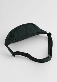 Casquette noire rembourrée de forme incurvée, avec une surface texturée et une sangle réglable munie d'une boucle en plastique sur un côté.