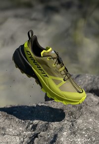 Παπούτσι trail running με ανοιχτό καφέ και νεον κίτρινο χρώμα. Δίχτυ στην επάνω πλευρά, μοτίβο στη σόλα και διακριτό λογότυπο "DYNAFIT" στο πλάι.