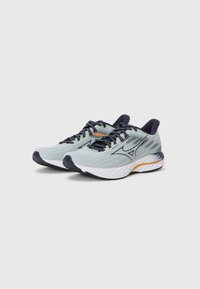 Helles blaues Laufschuhe mit dunkelblauen Schnürsenkeln, Obermaterial aus Mesh, strukturiertem Oberflächendesign und weißer, gepolsterter Sohle mit orangefarbenen Akzenten.