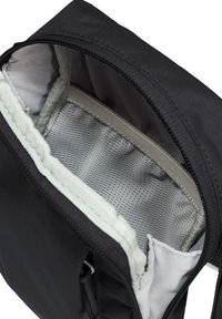 Sac noir à fermeture éclair ouvert dévoilant une poche intérieure en maille grise et une doublure en tissu gris clair.