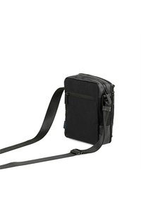 Bolso bandolera negro con tela duradera, forma rectangular, correa ajustable y múltiples compartimentos con cremallera.