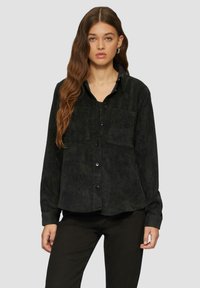Zwarte corduroy overhemd met lange mouwen, knoopsluiting aan de voorkant, twee borstzakken en een licht gebogen zoom. Getextureerde stof met verticale lijnen.