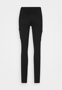 Pantalon noir slim-fit avec poches arrière et poches cargo latérales, montré de dos sur un fond uni.