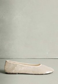 Bēšas baleta kurpes no teksturēta auduma ar spīdīgu spīguļu dizainu. Aprīkotas ar apaļu purngalu un plānu, elastīgu zolīti.