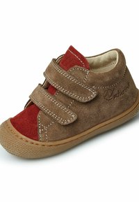 Scarpa in suede marrone con accenti rossi, dotata di due cinturini in velcro, suola texture e dettagli di cucitura. Design della punta arrotondata.