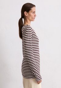 Długosleeve'owa koszula w paski w kolorze brązowym i kremowym, z okrągłym dekoltem i dopasowanym krojem, wykonana z miękkiej bawełny.