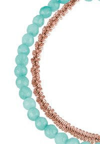 Primer plano de dos pulseras: una con cuentas de turquesa facetadas y la otra con anillos interconectados de metal rosa dorado.