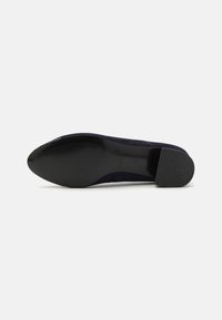 Navy blue suede shoe with a rounded toe, low block heel, and a textured black rubber sole featuring horizontal grooves.