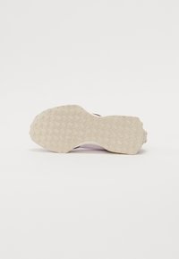 Hvit sneaker med en teksturert gummisåle med sirkulære topper, en glatt overdel og en bakre flik for enkel påkledning. Minimalistisk design.