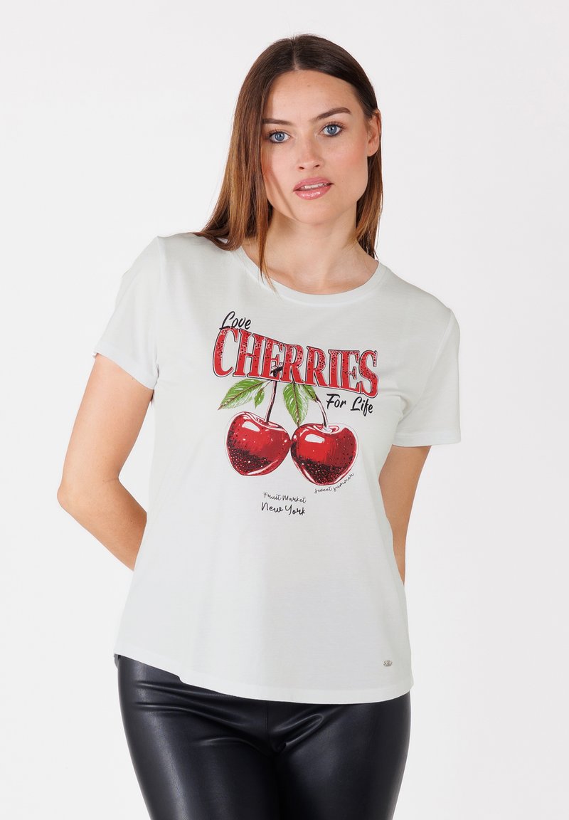 T-shirt en coton blanc avec un motif de cerises rouges et le texte "Aimez les CERISES Pour la Vie", accompagné d'une signature et de "Fruit Market New York."