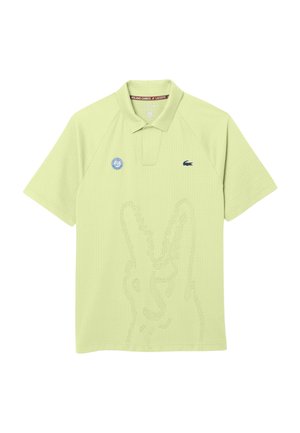 Polo de color verde claro con el logo de Roland Garros en el pecho izquierdo y el pequeño emblema del cocodrilo de Lacoste en el pecho derecho.
