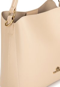 Borsa a tracolla in pelle beige con una texture liscia, hardware dorato, design semplice e cuciture visibili sui lati. Logo del brand impresso.