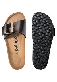 Svart lädersklidesandal med ett guldspänne, brun vadderad innersula och texturerad svart yttersula med en vågig mönstring. Märke: Palado.