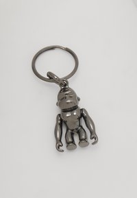 Metal nøglering med en stiliseret abefigur. Den har en blank, mørk overflade med bevægelige arme og ben samt en rund fastgørelsesring.